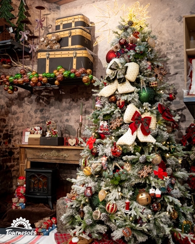 Sapin de Noël décoré dans un style country, entouré de décorations rustiques.